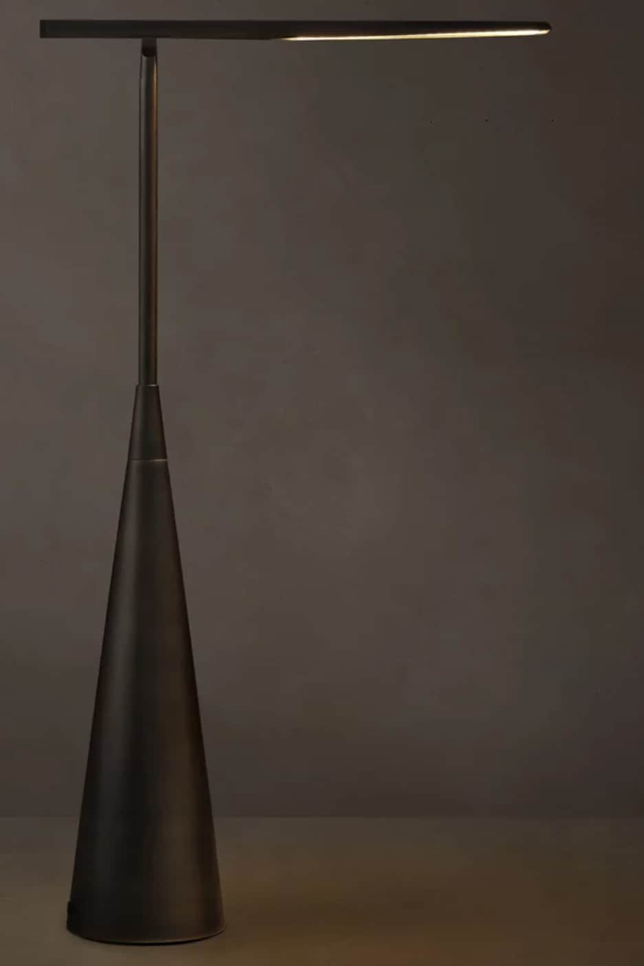 A modern floor lamp featuring a slender, dark metallic pole rising from a wide, inverted conical bas… — 3D model