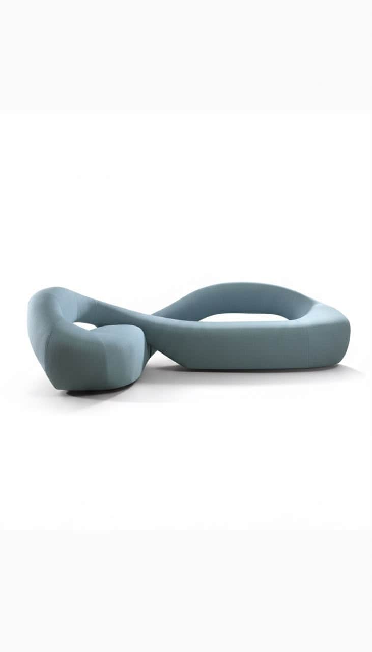 A sculptural, modern serpentine sofa upholstered in a light blue or teal fabric. The piece features… — 3D model