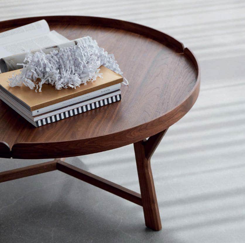 A modern round coffee table featuring a distinctive tray-style top and three splayed wooden legs, fi… — free BLEND 3D model