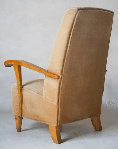 A vintage armchair with a high back and upholstered in a light brown, velvety fabric. The armrests a… — 3D model