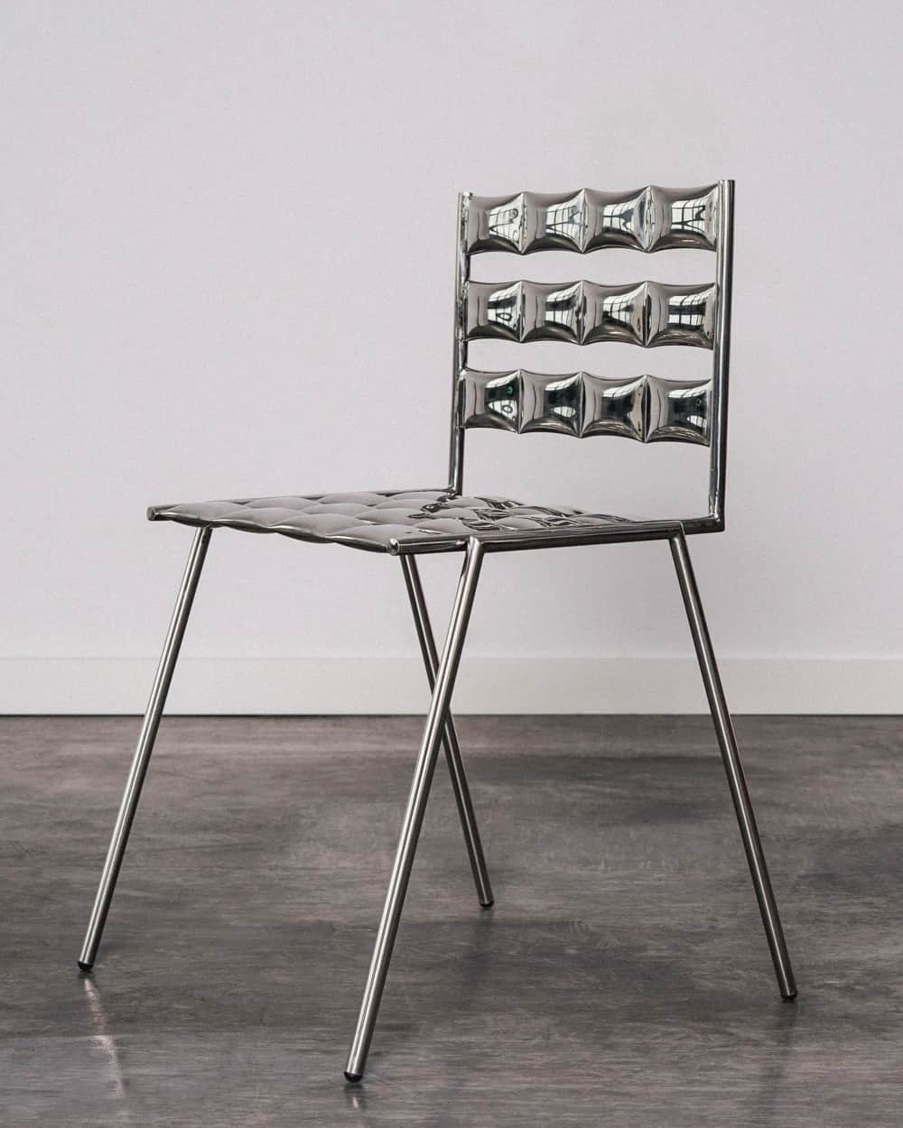 A modern chair with a distinctive design featuring a highly reflective, metallic finish. The seat an… — free FBX 3D model