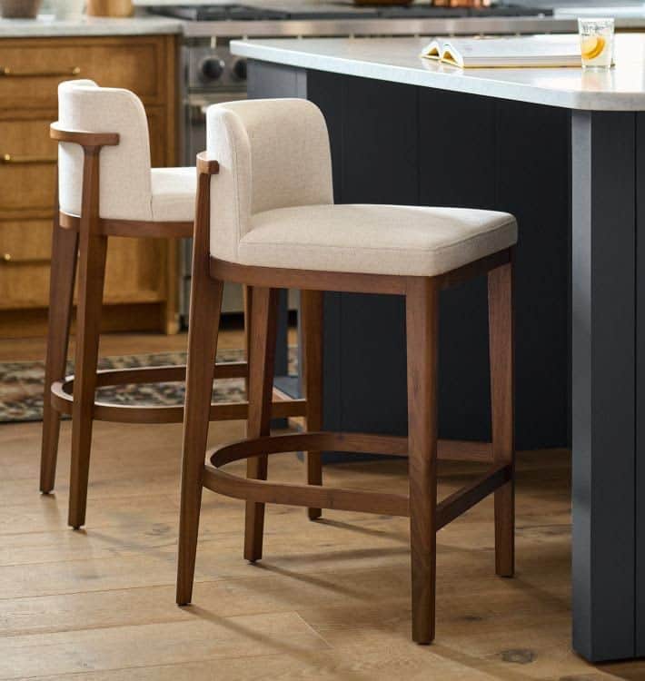 A modern bar stool featuring a sturdy dark brown wooden frame, an upholstered seat, and a low curved… — 3D model