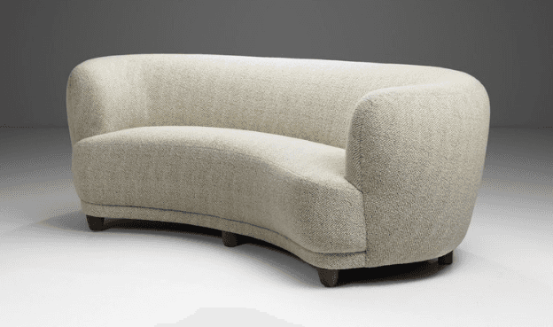 A curved, fully upholstered sofa featuring a serpentine form, rounded back and integrated armrests,… — 3D model