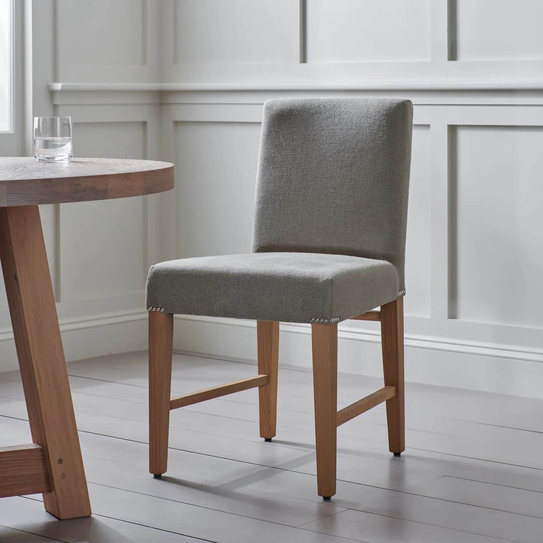 A high-backed upholstered chair with a square seat and four wooden legs. The upholstery is a texture… — 3D model