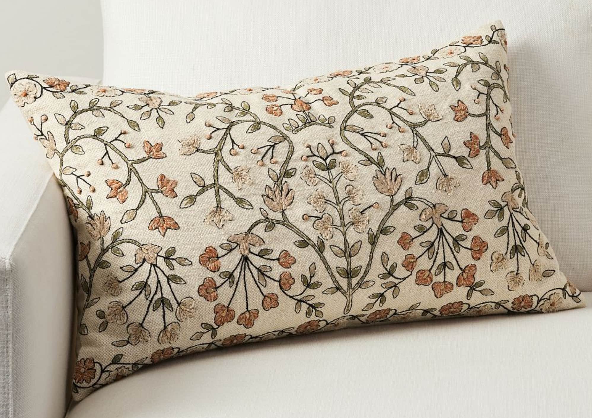 A rectangular lumbar pillow with an embroidered floral pattern on a neutral background. The embroide… — 3D model