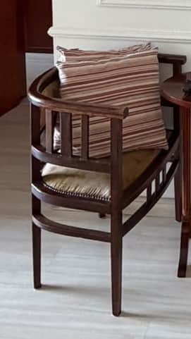 A compact armchair featuring a dark stained wooden frame with a distinctive barrel-shaped, curved ba… — free OBJ 3D model