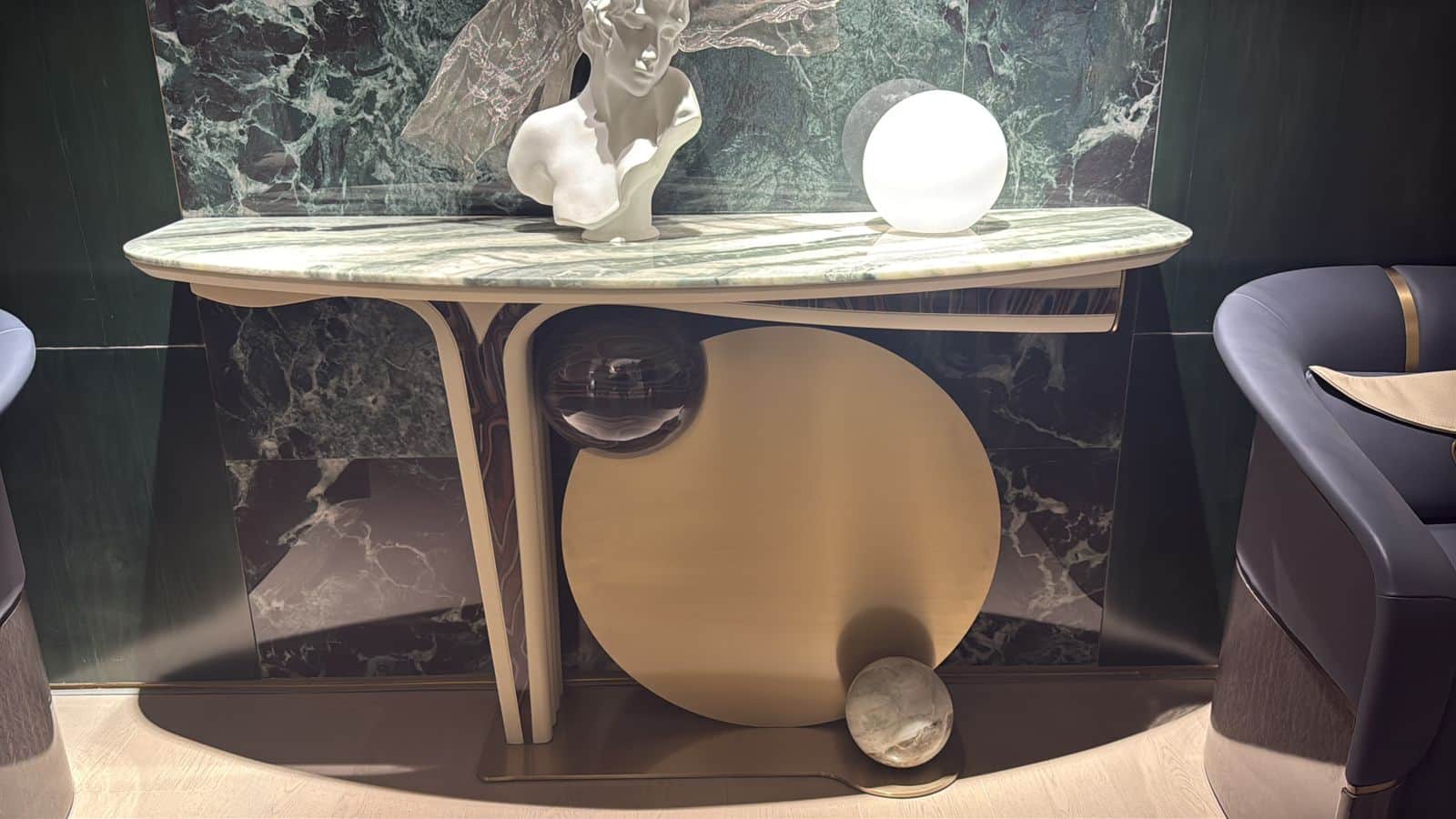 An elegant and sculptural console table featuring a grey and green veined marble top with an asymmet… — 3D model