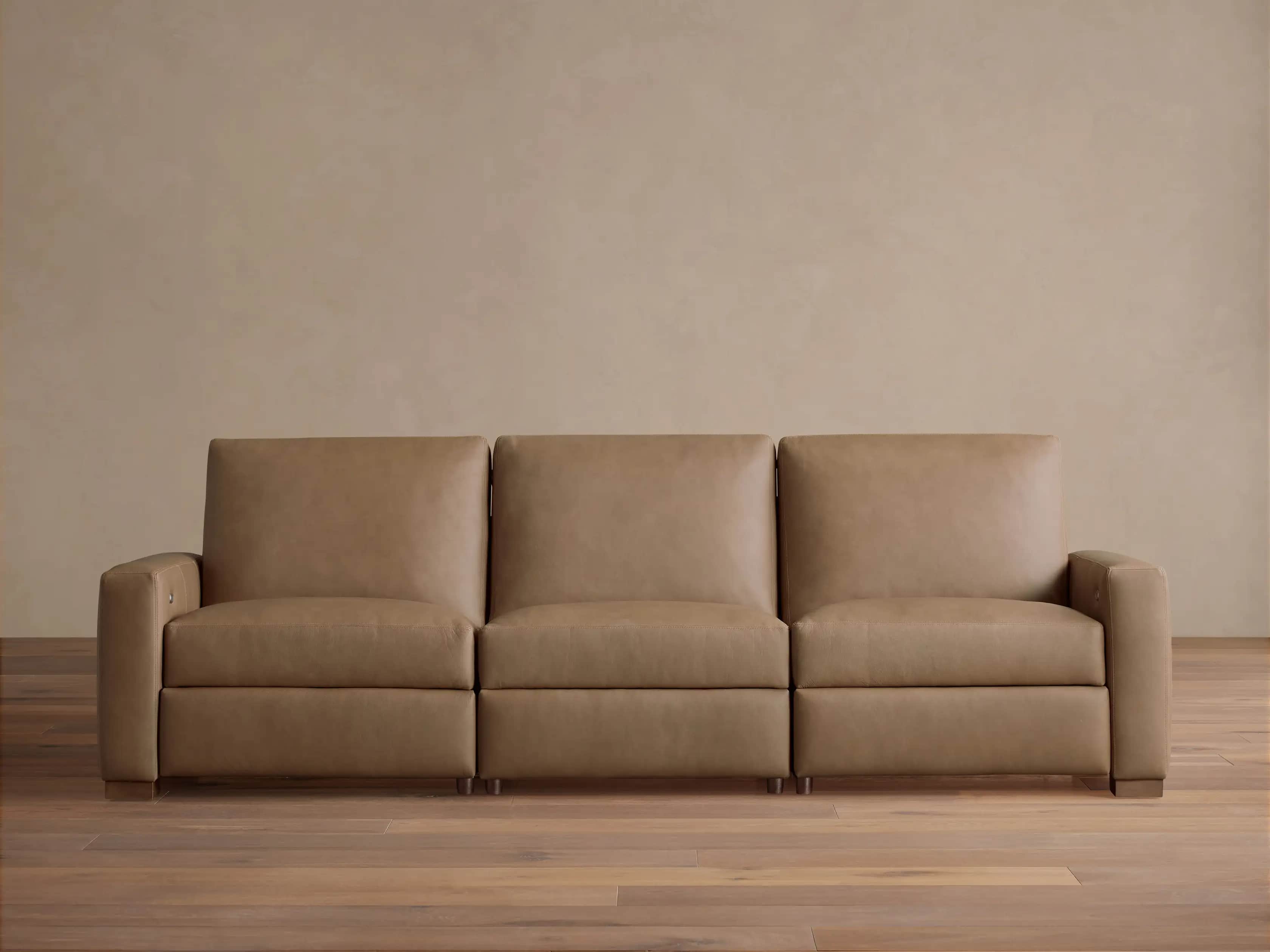 A modern three-seater sofa upholstered in a light tan or beige leather-like material. It features th… — free GLTF 3D model