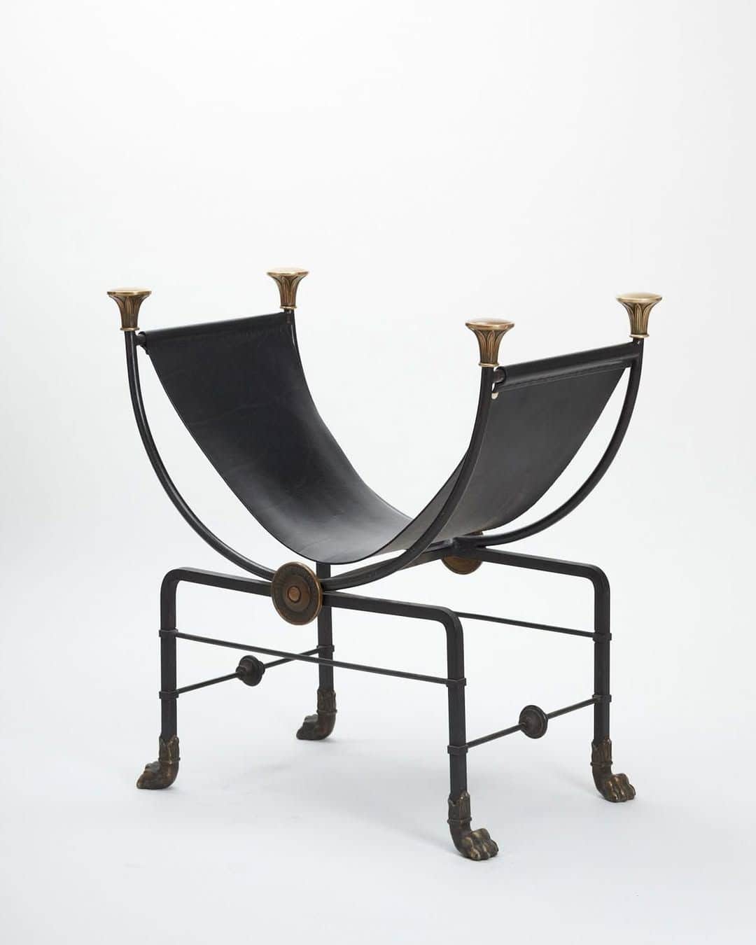 A decorative log holder or magazine rack featuring a black wrought iron or steel frame with brass ac… — 3D model