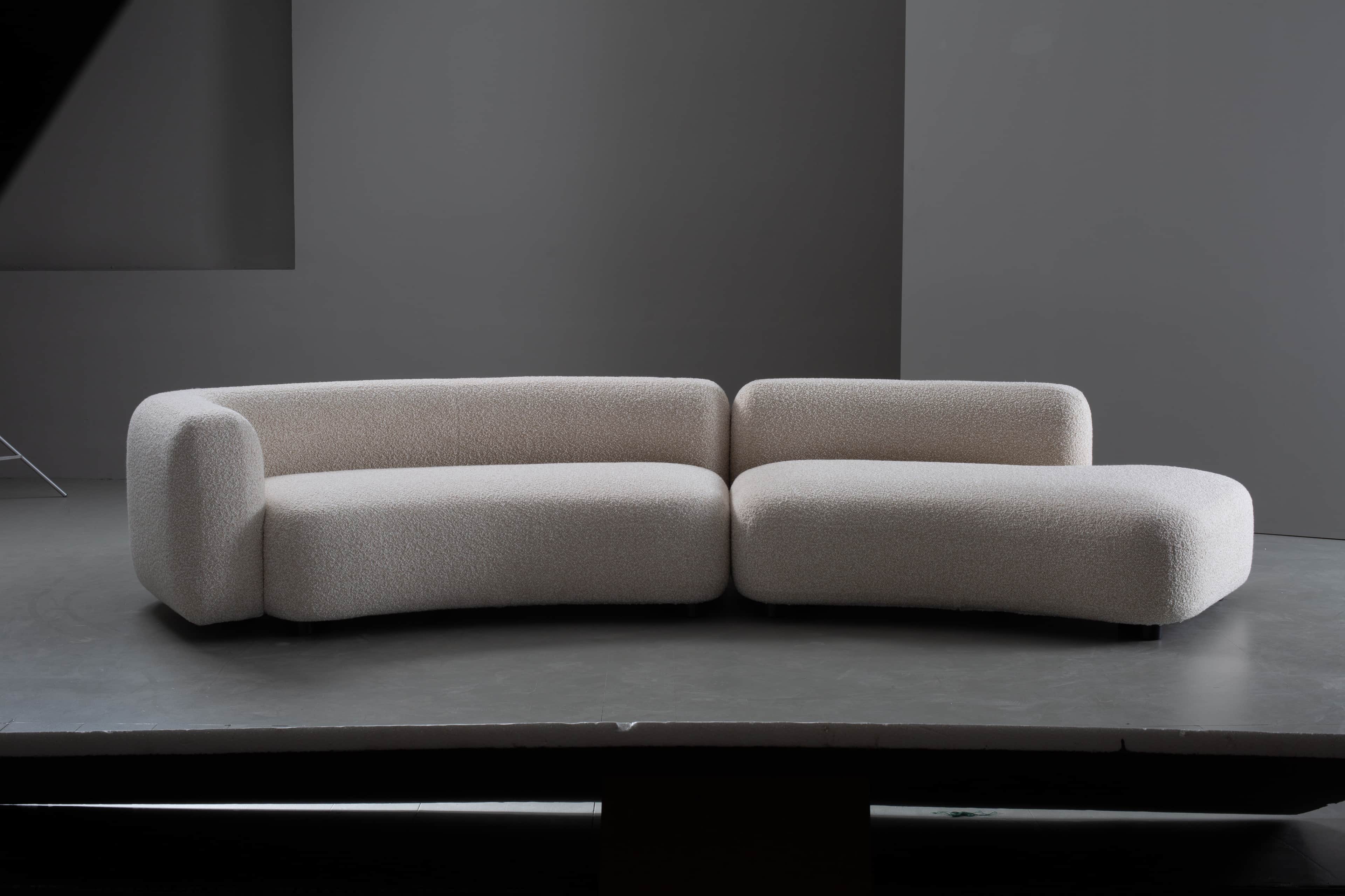 A two-piece modular sofa featuring a distinct curved silhouette and upholstered in a light-colored,… — 3D model