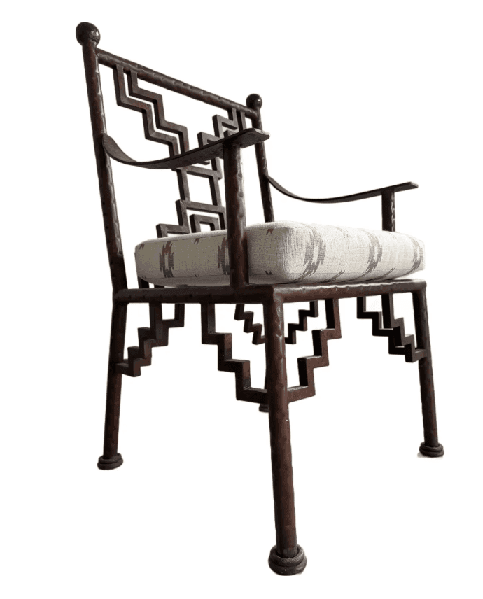 An armchair with a dark brown, possibly metal, frame featuring a geometric, stepped pattern on the b… — free OBJ 3D model