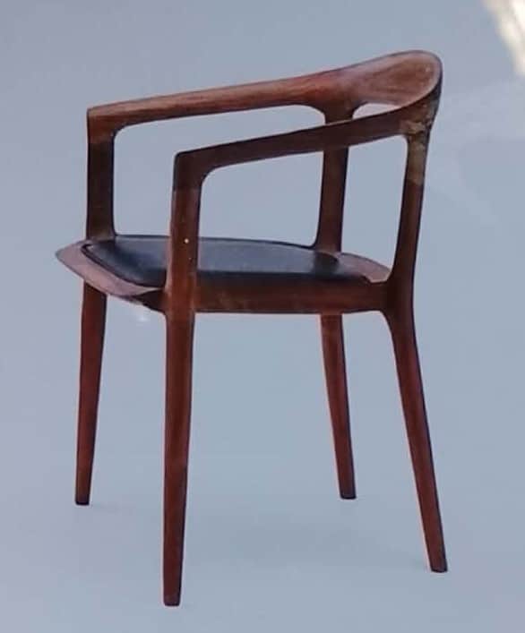 A modern dining chair crafted from dark brown wood, featuring a curved backrest that seamlessly inte… — free GLTF 3D model