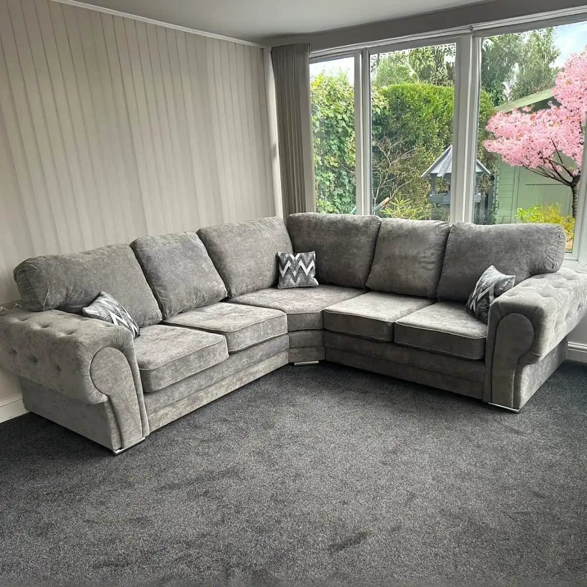 A large, L-shaped sectional sofa upholstered in light gray fabric, featuring button tufting on the r… — 3D model