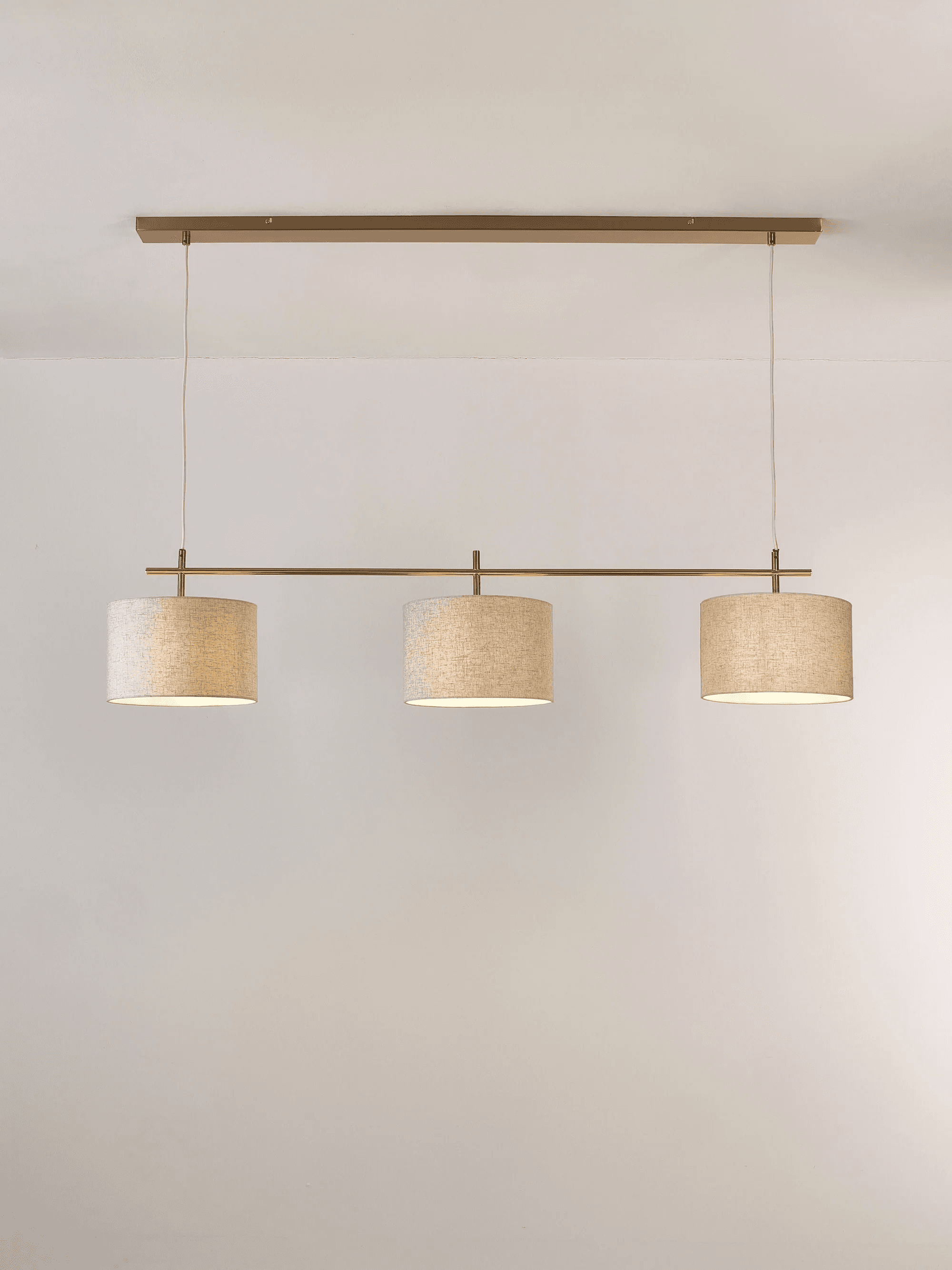 A linear pendant light fixture with a rectangular brass-finished metal bar mounted horizontally to t… — 3D model