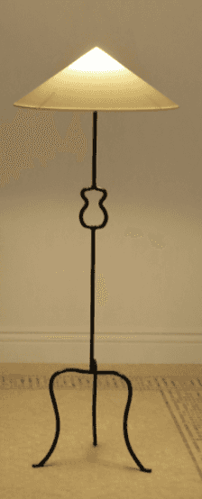 A freestanding floor lamp featuring a dark, possibly wrought iron, tripod base with scrolled legs an… — 3D model