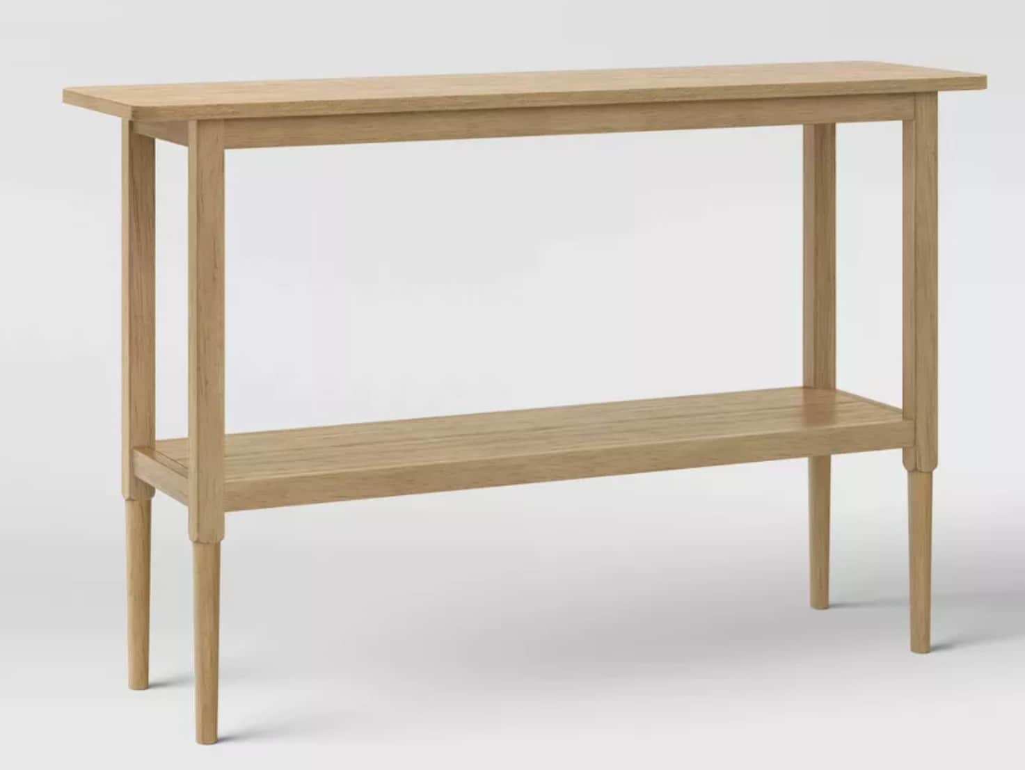 A light-toned wooden console table featuring a rectangular top surface and a lower shelf. The table… — 3D model