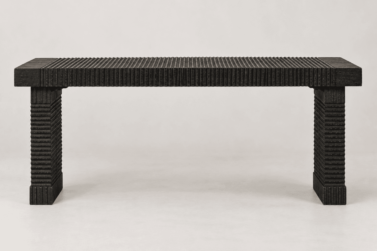 A dark-colored, rectangular bench with a heavily textured, fluted surface, supported by two thick, r… — 3D model