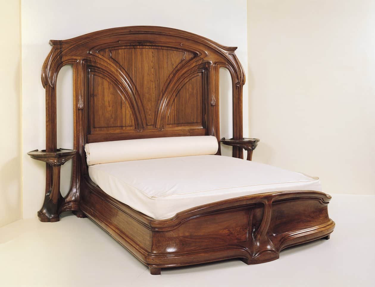 An Art Nouveau-style bed featuring a highly ornate, carved dark wood frame. The headboard is tall an… — free BLEND 3D model