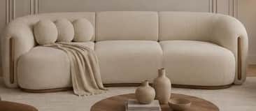 A long, contemporary curved sofa upholstered in a light, textured fabric, featuring a sleek, low-pro… — free GLTF 3D model