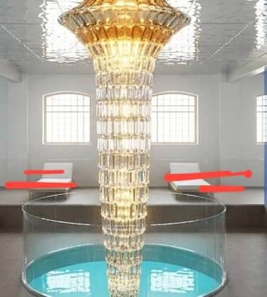 A large, tiered chandelier composed of numerous faceted amber-toned crystal or glass elements, formi… — 3D model