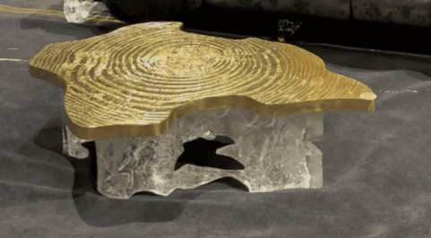 A striking coffee table featuring an irregular, organic-shaped tabletop made of polished golden bras… — 3D model