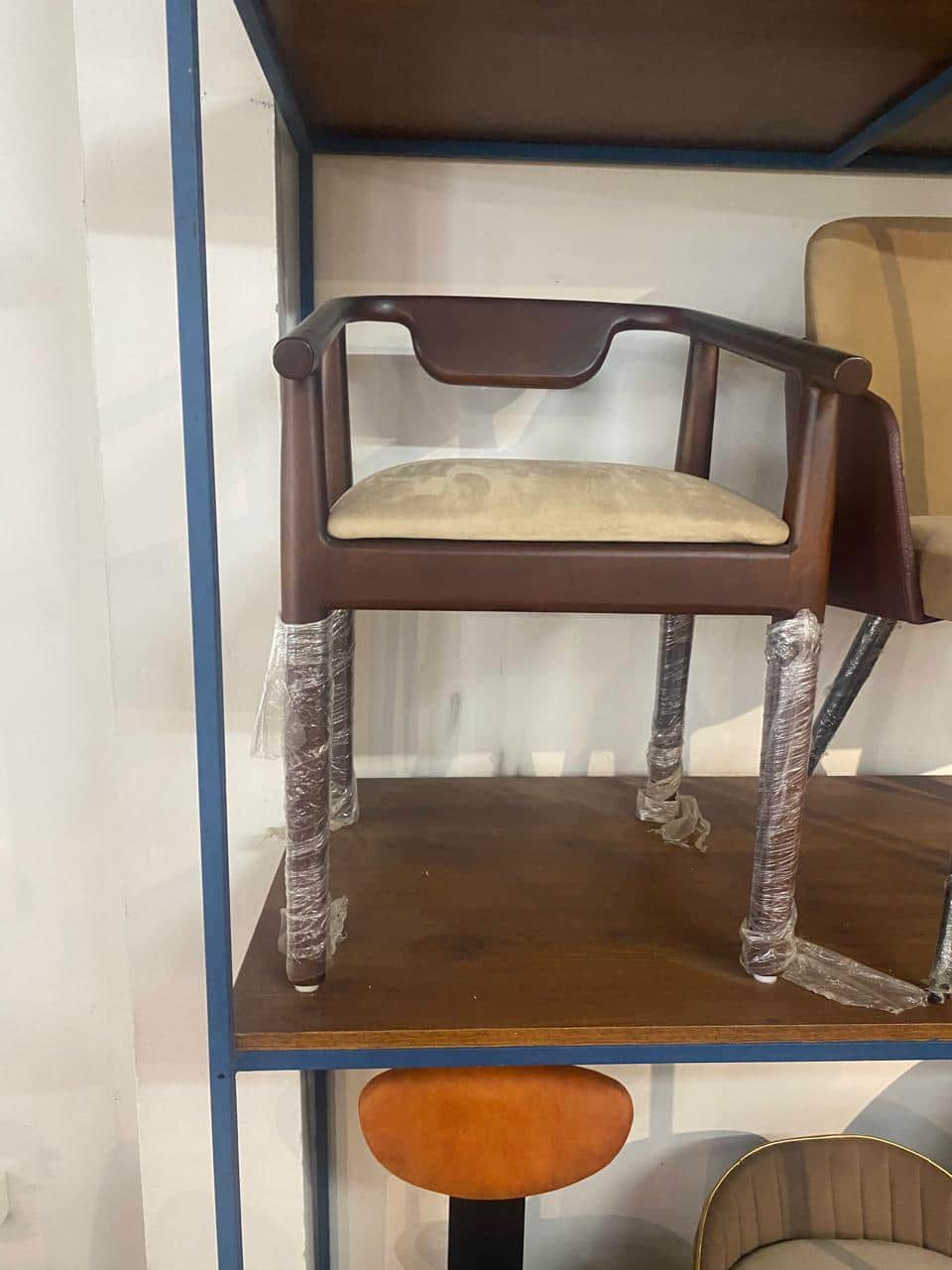 A contemporary armchair featuring a dark stained wooden frame and a light beige upholstered seat. It… — 3D model
