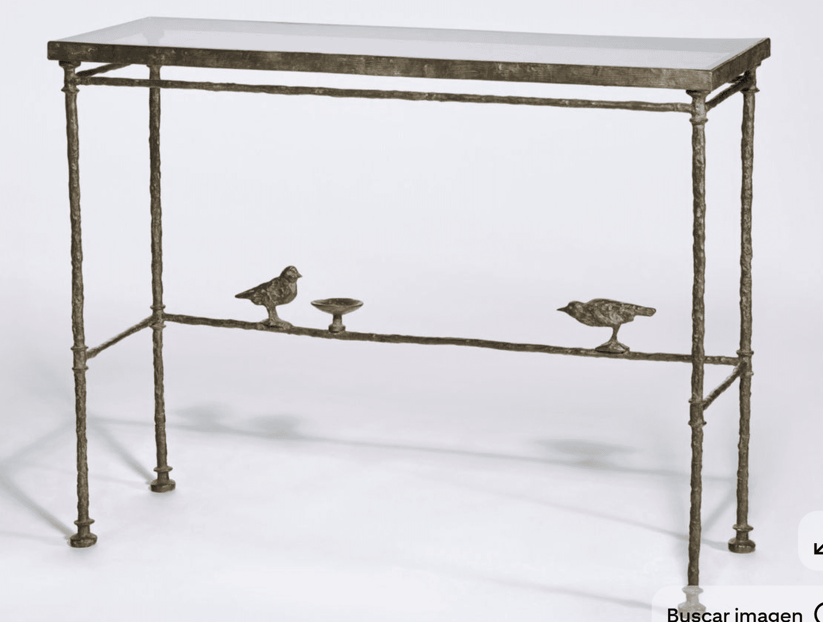 A slender console table with a glass top and a decorative metal base. The base is designed to resemb… — 3D model