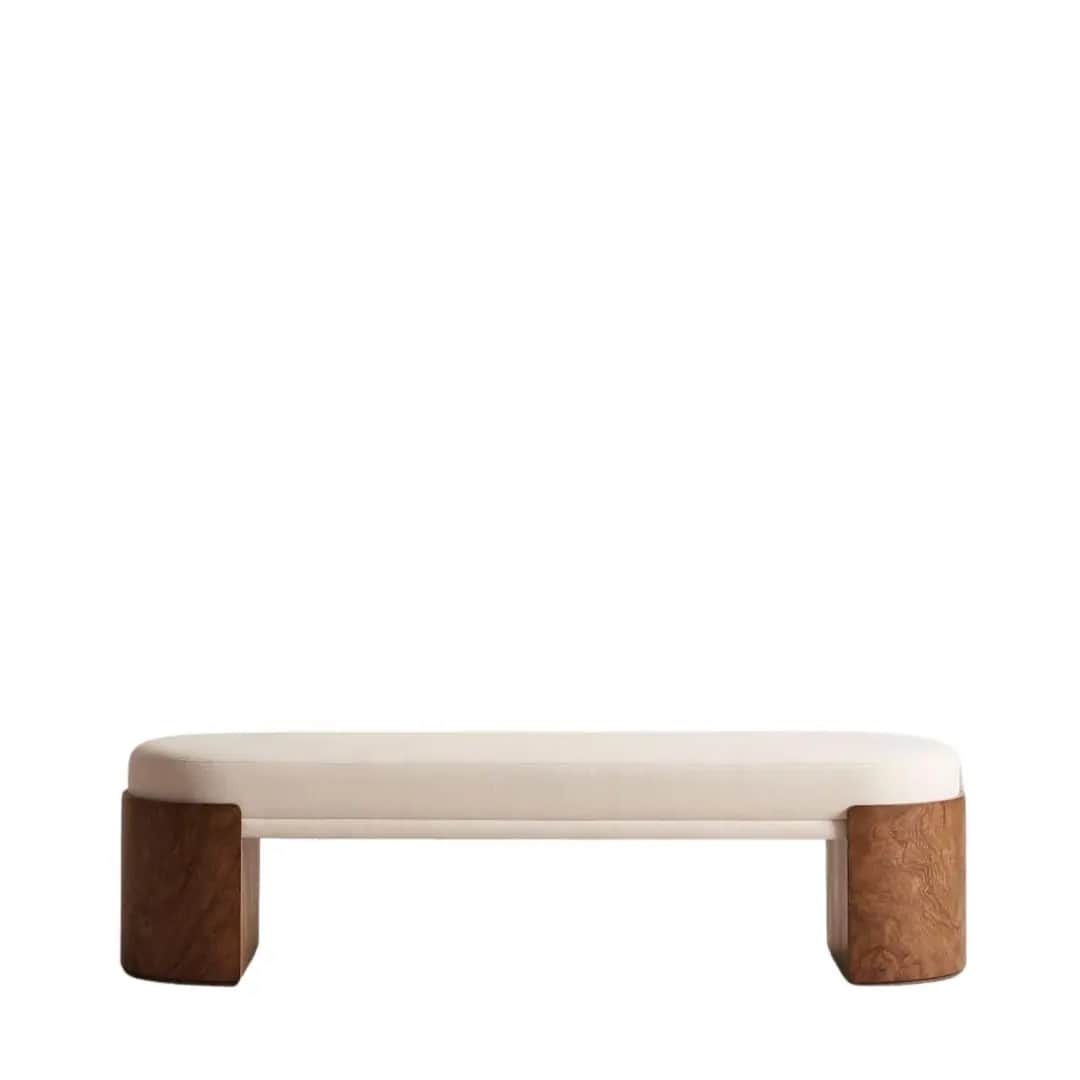A modern upholstered bench featuring a cream-colored top with rounded edges and supported by two sub… — 3D model
