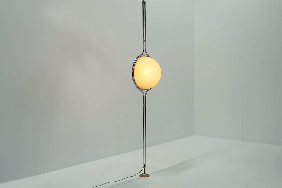 A modern floor lamp with a spherical, frosted glass shade suspended from a slender, metallic stem. T… — 3D model