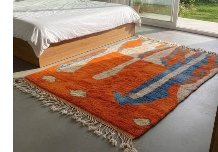 A rectangular rug with a vibrant abstract pattern featuring bold orange shapes interspersed with blu… — 3D model