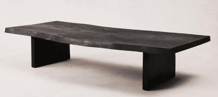 A low-profile, rectangular coffee table featuring a live-edge solid wood top and two robust slab leg… — free BLEND 3D model