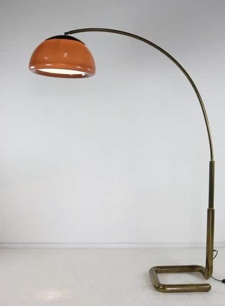A modern arc floor lamp featuring a slender, arching brass-toned metal arm and a distinctive terraco… — 3D model