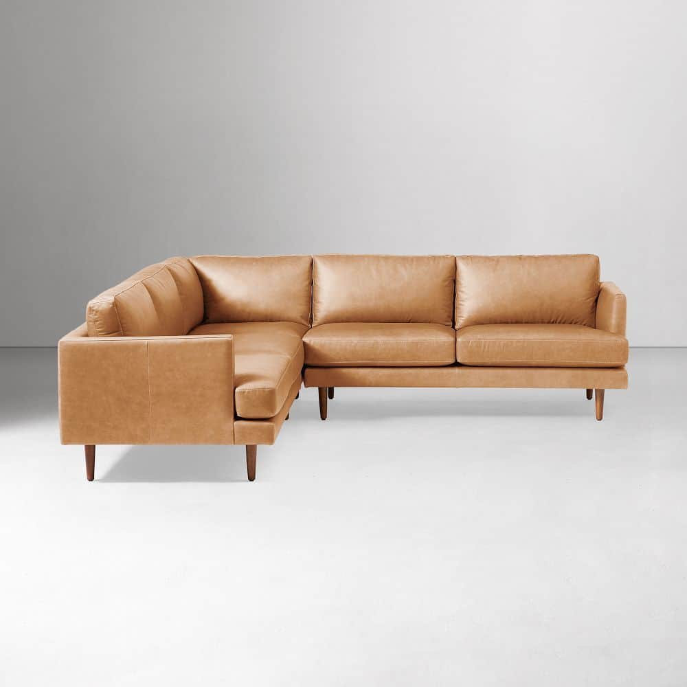 An L-shaped sectional sofa upholstered in tan leather, featuring a modern low-profile design with sq… — 3D model