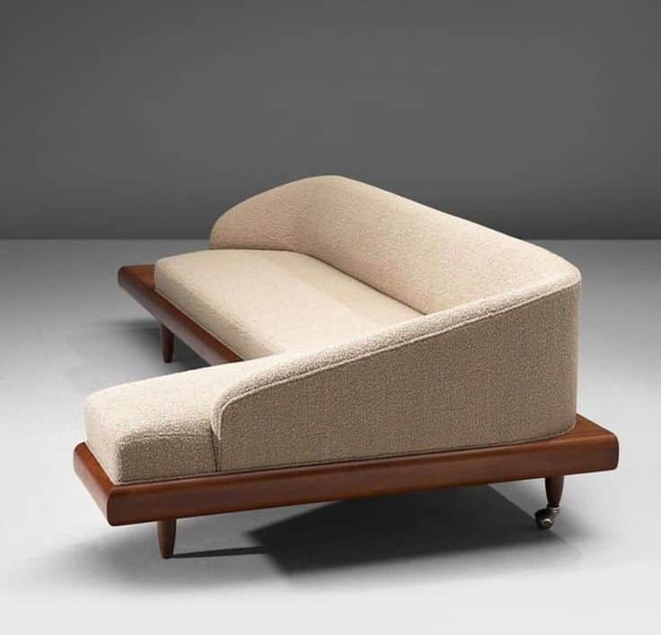 An L-shaped sectional sofa piece featuring a light-colored, textured upholstered seat and a gently c… — 3D model