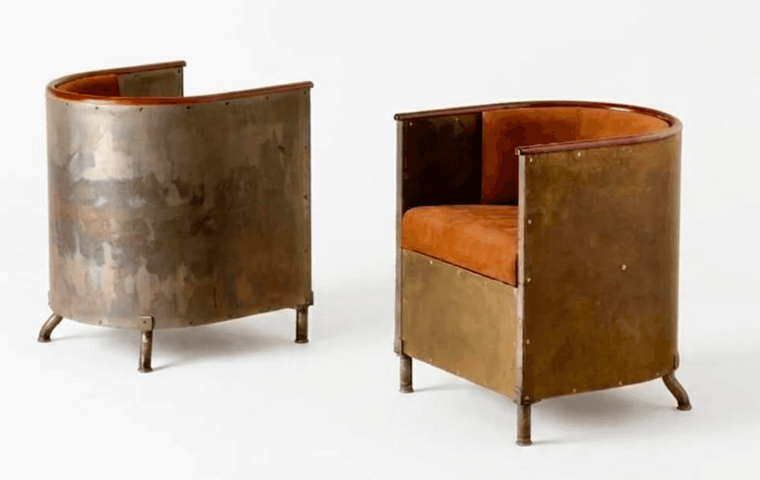 An industrial-style barrel armchair featuring a curved metal frame with visible rivets and a patinat… — 3D model