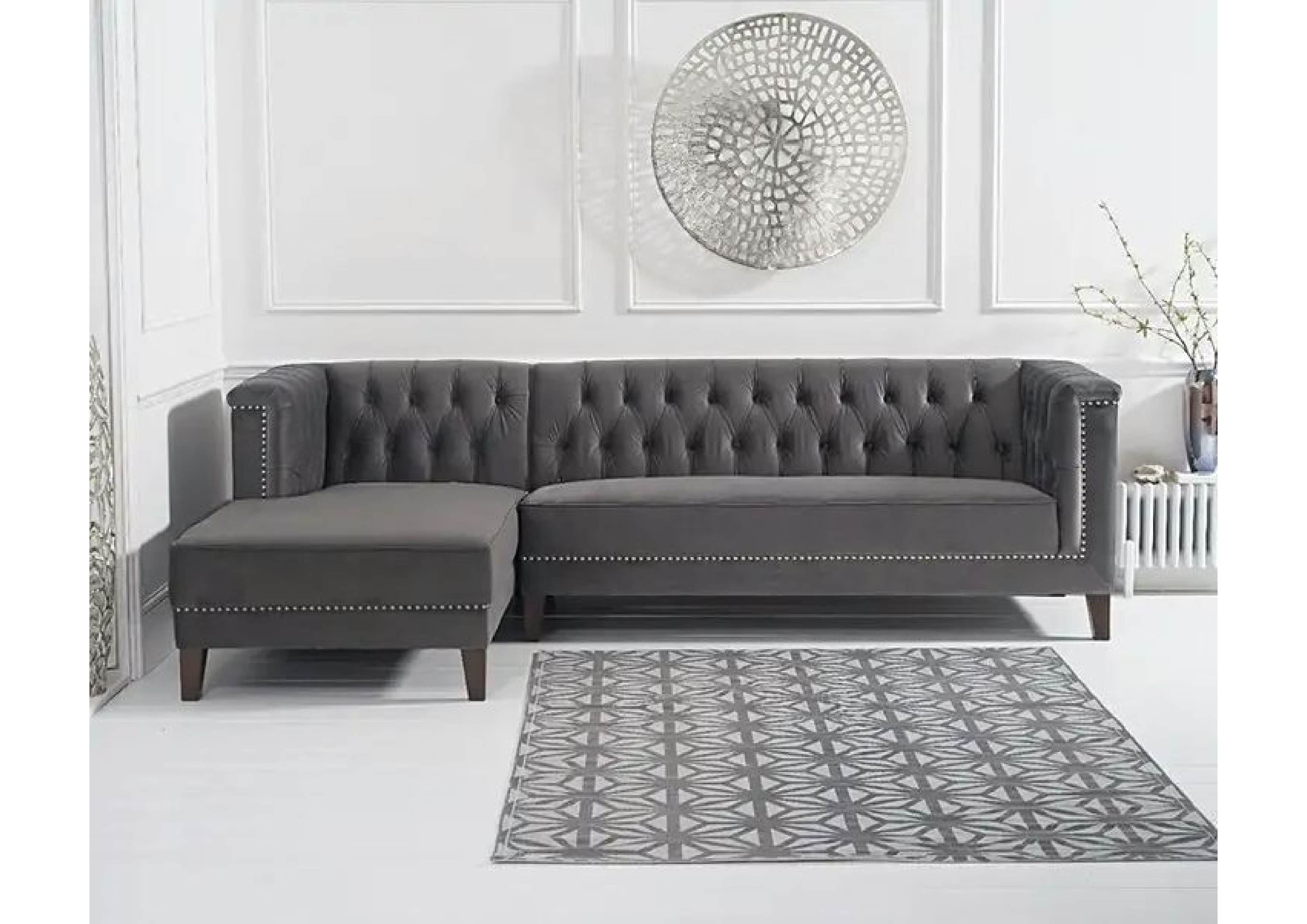 A dark grey sectional sofa featuring a left-hand facing chaise, distinguished by deep button tufting… — 3D model