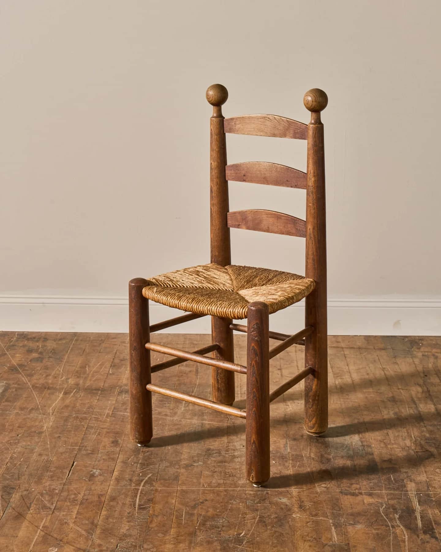 A rustic wooden side chair featuring a distinctive ladder back with three horizontal slats, a woven… — 3D model