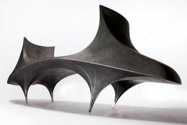 A sculptural bench with an organic, flowing form. The bench features a dark, matte finish and appear… — free SKP 3D model