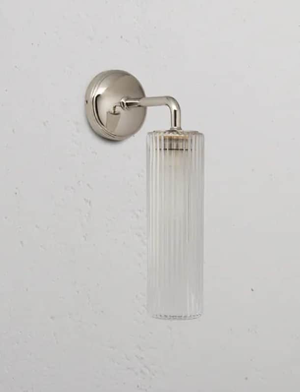 A modern wall sconce featuring a cylindrical ribbed glass shade attached to a polished metal arm and… — free OBJ 3D model