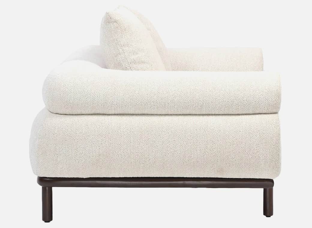A side view of a contemporary sofa featuring thick, rounded, cream-colored boucle upholstery and a m… — free GLTF 3D model