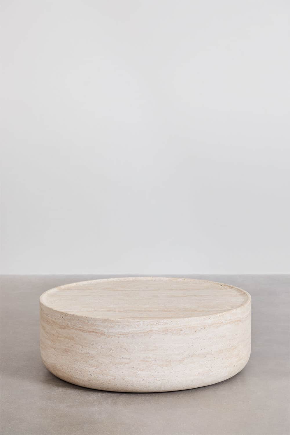 A low, cylindrical coffee table made from solid beige travertine stone. It features a flat top surfa… — 3D model