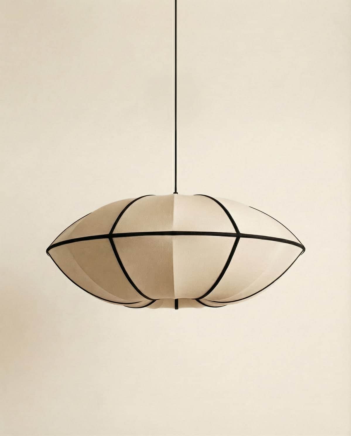 A pendant light fixture featuring an oval-shaped shade constructed from fabric panels stretched over… — 3D model