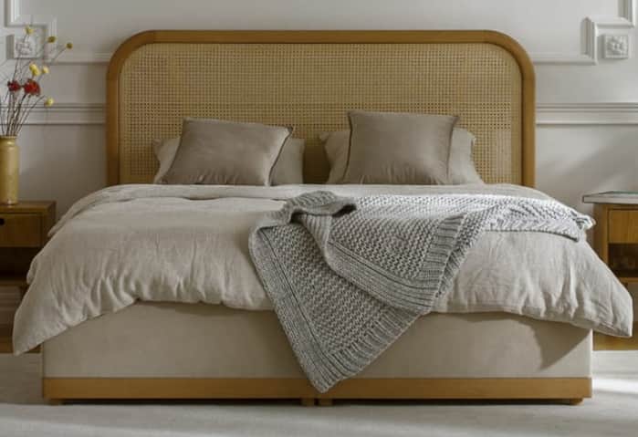 A modern platform bed featuring a light natural wood frame, a rounded headboard with cane webbing, a… — 3D model