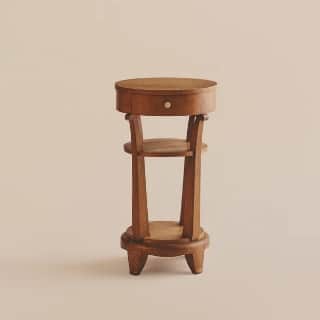 A small, round, wooden side table with a single drawer and a lower shelf. The table features a circu… — 3D model
