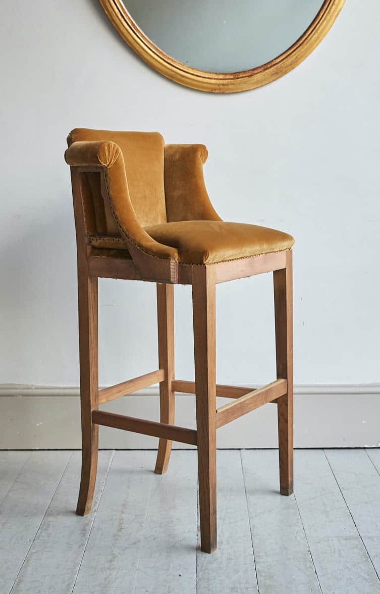 A high bar stool with a upholstered seat and backrest, featuring rolled arms and a wooden frame. The… — free SKP 3D model