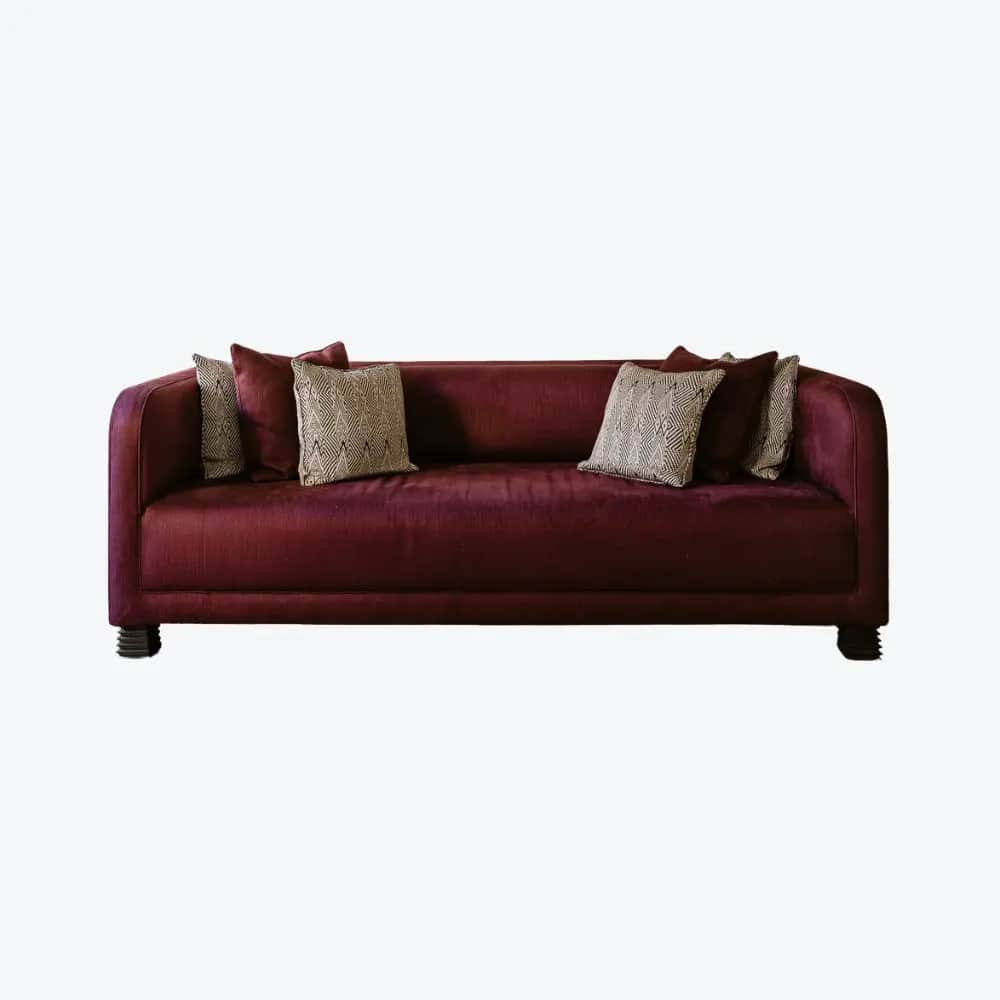 A three-seater sofa with a curved back and arms. It is upholstered in a deep red fabric with a subtl… — 3D model