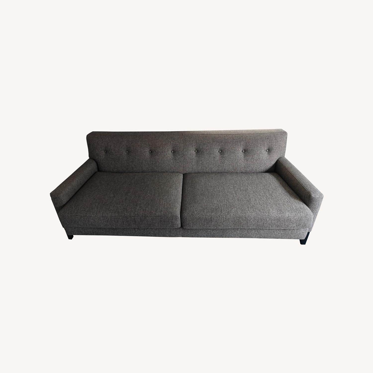 A contemporary sofa upholstered in a heathered gray fabric, featuring a button-tufted backrest and f… — 3D model