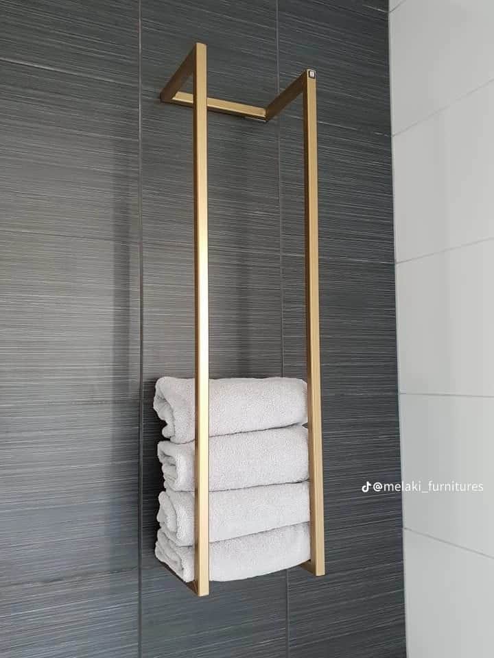 A minimalist, rectangular, floor-standing towel stand constructed from gold-colored metal. It featur… — 3D model