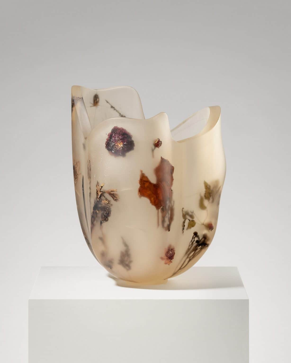 A translucent decorative vase with an organic, undulating rim, crafted from resin with various dried… — 3D model