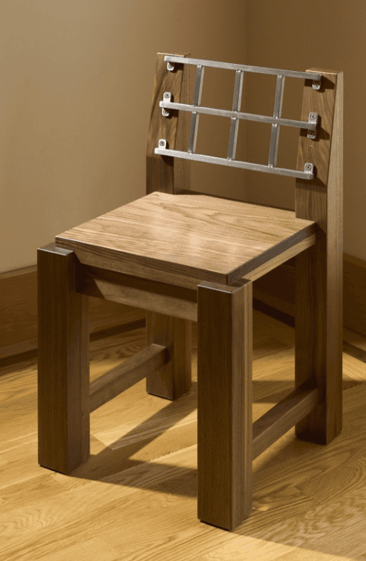 A modern wooden chair with a distinctive metal backrest. The chair features a solid wood seat and le… — 3D model